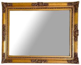 A REGENCY STYLE GILT FRAMED MIRROR With carved cartouches. (100cm x 80cm) Condition: good overall