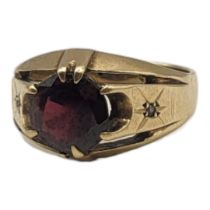 A VINTAGE 9CT GOLD AND GARNET GENTS SIGNET RING Having a single round cut stone and diamond chips to