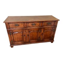 AN 18TH CENTURY STYLE SOLID OAK DRESSER, with three drawers above ogee panelled cupboards, on