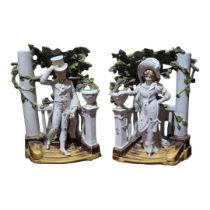 A PAIR OF EDWARDIAN BISQUE BOOKENDS Formed as a courting couple on stone steps. (28cm)