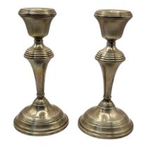 A PAIR OF MID CENTURY SILVER CANDLESTICKS Having horizontal bands with circular base, hallmarked