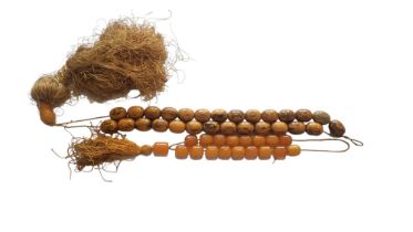 A VINTAGE BUTTERSCOTCH AMBER NECKLACE The row of uniform beads with fabric tassel, together with a