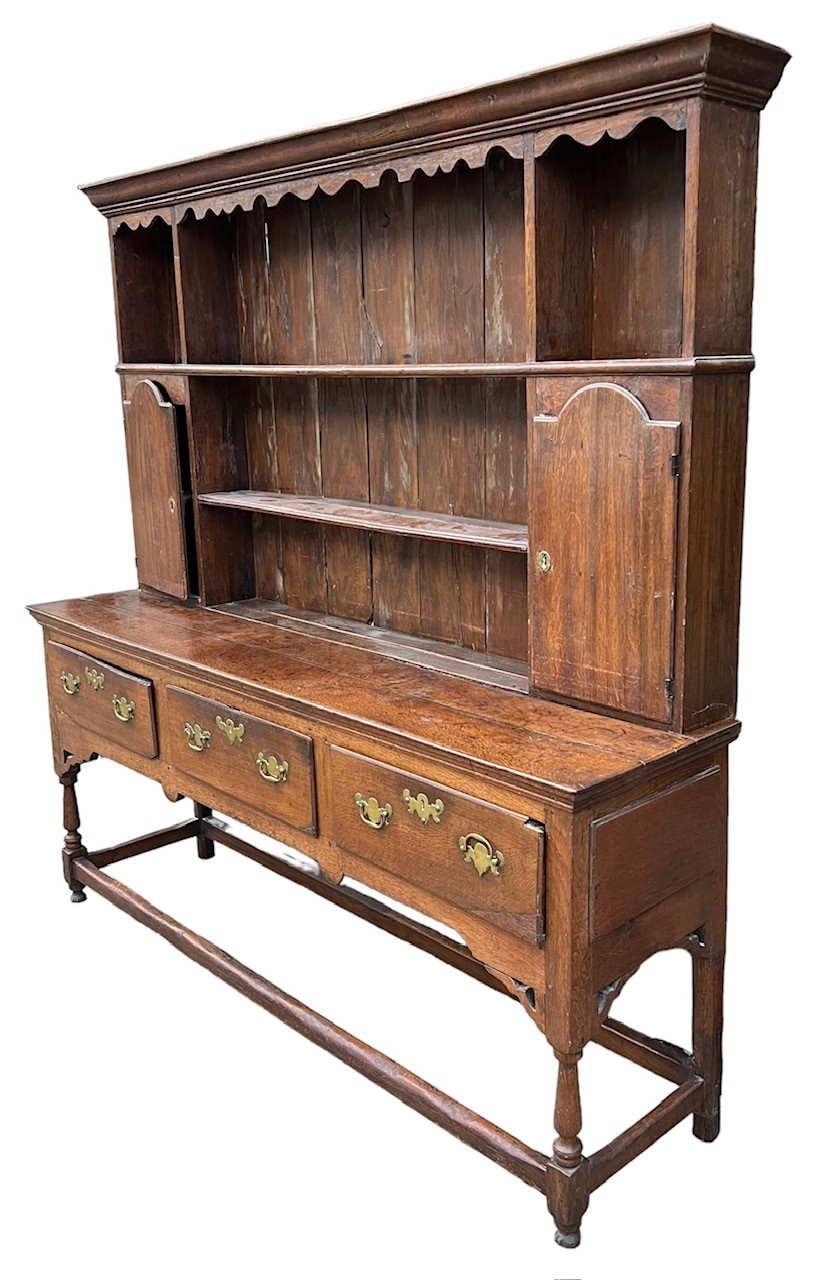 AN 18TH CENTURY OAK DRESSER The cornice above a shaped apron and shelves and two cupboard doors - Image 2 of 3