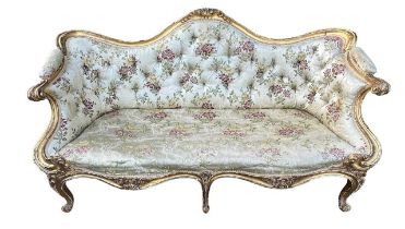 MANNER OF THOMAS CHIPPENDALE, A GEORGE III CARVED GILTWOOD SETTEE The shaped back decorated with