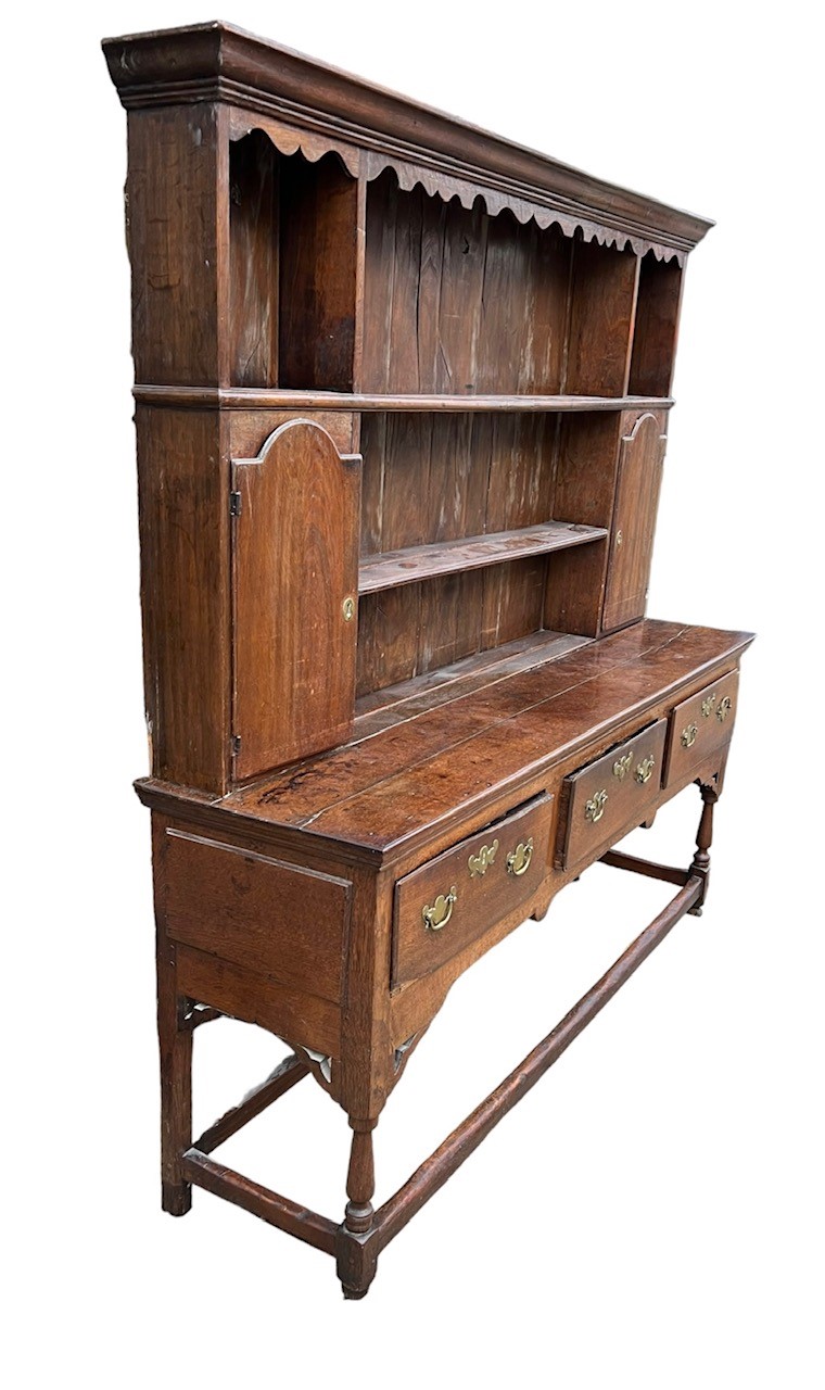 AN 18TH CENTURY OAK DRESSER The cornice above a shaped apron and shelves and two cupboard doors - Image 3 of 3