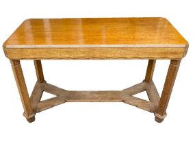 A 20TH CENTURY OAK COTSWOLD SCHOOL DINING TABLE The counted corner top with carved freeze, raised on