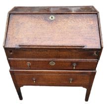 AN 18TH CENTURY TWO SECTION OAK WRITING BUREAU The fall front opening to reveal fitted interior