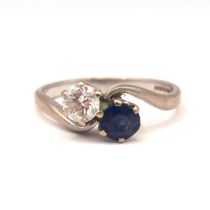 A VINTAGE 18CT WHITE GOLD, DIAMOND AND SAPPHIRE CROSSOVER RIN The claw set brilliant round cut