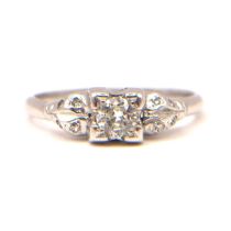 A VINTAGE DIAMOND AND WHITE METAL RING (WHITE METAL TESTED AS PLATINUM) The central brilliant