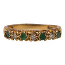 A 9CT GOLD, SEVEN STONE EMERALD & DIAMOND RING. Three brilliant round cut diamonds (approx.