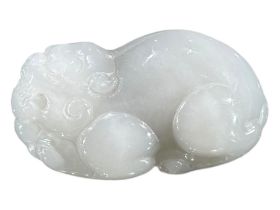 A CHINESE WHITE JADE CARVING OF A MYTHICAL QILIN Recumbent position. (h 4cm x w 6.9cm x d 3.6cm)