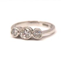 A VINTAGE 18CT WHITE GOLD AND THREE STONE DIAMOND RING Bezel set brilliant round cut diamond (approx