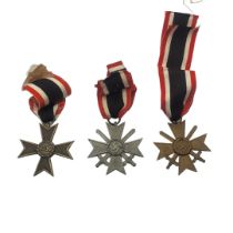 A COLLECTION OF THREE WWII GERMAN WAR MERIT CROSS MEDALS Two with swords, marked 1936.