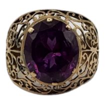 A VINTAGE YELLOW METAL AND AMETHYST GENTS SIGNET RING Oval faceted cut stone in a wide pierced
