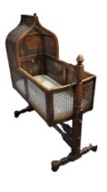 WITHDRAWN! A 19TH CENTURY CHILD'S MAHOGANY AND CANE CRIB ON STAND With pointed arched top