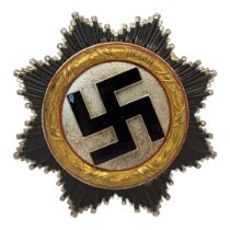 A GERMAN WWII WAR ORDER OF THE GERMAN CROSS MEDAL Gold bezel dated1941, black enamel swastika. (
