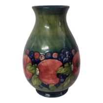 A WILLIAM MOORCROFT POTTERY BALUSTER VASE, CIRCA 1930 In pomegranate, berry and leaf pattern, the