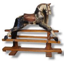 AN EARLY 20TH CENTURY CHILD’S DAPPLE GREY WOODEN ROCKING HORSE With real hair mane and tan leather