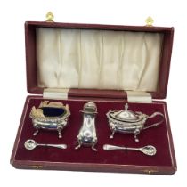 AN EARLY 20TH CENTURY SILVER AND BLUE GLASS CRUET SET Comprising a salt, pepper, mustard and spoons,