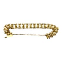 A CONTINENTAL 18CT GOLD BRACELET Having pierced circular links and safety chain. (approx 17cm)