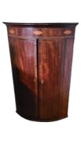 A GEORGIAN MAHOGANY AND SHELL MARQUETRY INLAID BOW FRONTED CORNER CABINET With two doors enclosing