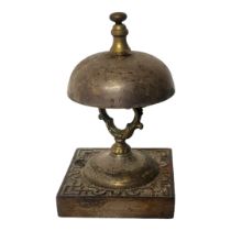 A LATE 19TH CENTURY BRASS AND CAST METAL NOVELTY TABLE BELL PUSH Raised on a square base, Circa