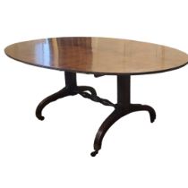A GEORGIAN SOLID MAHOGANY DINING TABLE The oval tilt top with reeded border, raised on two columns