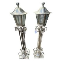 A PAIR OF STYLISH SILVER PLATED FLOOR STANDING LANTERN LAMPS With scrolling decoration. (h 150cm)
