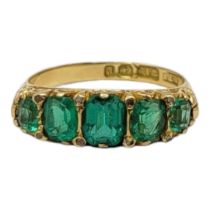 AN EARLY 20TH CENTURY 18CT GOLD AND PASTE SET FIVE STONE RING Having a row of emerald cut stones