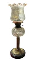 A VICTORIAN BRASS AND CUT GLASS OIL LAMP Having a fluted glass shade, cut glass oil well and twisted