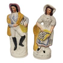 A PAIR OF VICTORIAN STAFFORDSHIRE FLATBACK FIGURES OF A FISHERMAN AND HIS WIFE Highlighted with
