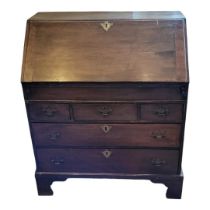 A GEORGE II PERIOD MAHOGANY BUREAU The fall front enclosing a fitted interior with well hole above