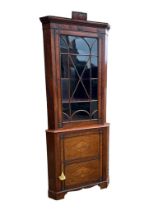 AN EARLY 19TH CENTURY MAHOGANY FLOOR-STANDING CORNER CABINET The single Gothic glazed door enclosing