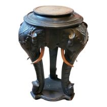 A LATE VICTORIAN EBONISED MAHOGANY PLANT STAND The circular top on three carved elephant legs