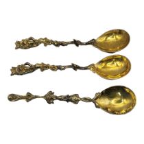 A SET OF THREE POLISH LITHUANIAN SILVER GILT ARMORIAL SPOONS Having figural finials and embossed