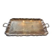 A LARGE EARLY 20TH CENTURY SILVER BUTLER'S TRAY Having twin handles and scrolled edge, hallmarked
