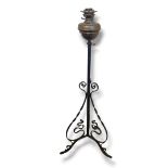 A LATE VICTORIAN BRASS AND WROUGHT IRON TELESCOPIC FLOOR STANDING OIL LAMP. (130cm unextended)