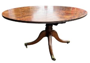 A 19TH CENTURY FLAME MAHOGANY OVAL TILT TOP BREAKFAST TABLE Supported on a turned pedestal base,