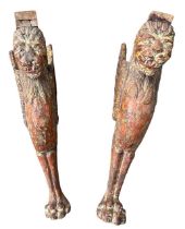 A PAIR OF ANTIQUE CARVED HARDWOOD AND POLYCHROME TABLE SUPPORTS IN THE FORM A MYTHICAL WINGED