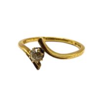 AN EDWARDIAN 18CT GOLD AND DIAMOND SOLITAIRE CROSSOVER RING The old European cut diamond (approx.