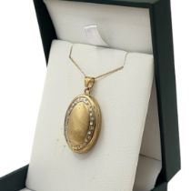 A VINTAGE 9CT GOLD OVAL PENDANT LOCKET Containing two compartments, on a fine link necklace chain,