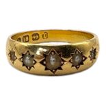 AN EARLY 20TH CENTURY 18CT GOLD AND SEED PEARL RING Having a row of graduated pearls in a rubover