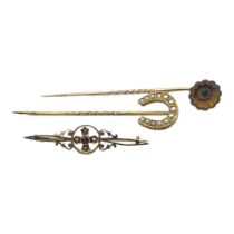 A VICTORIAN YELLOW METAL AND EMERALD STICK PIN The single emerald set in a floral design, together
