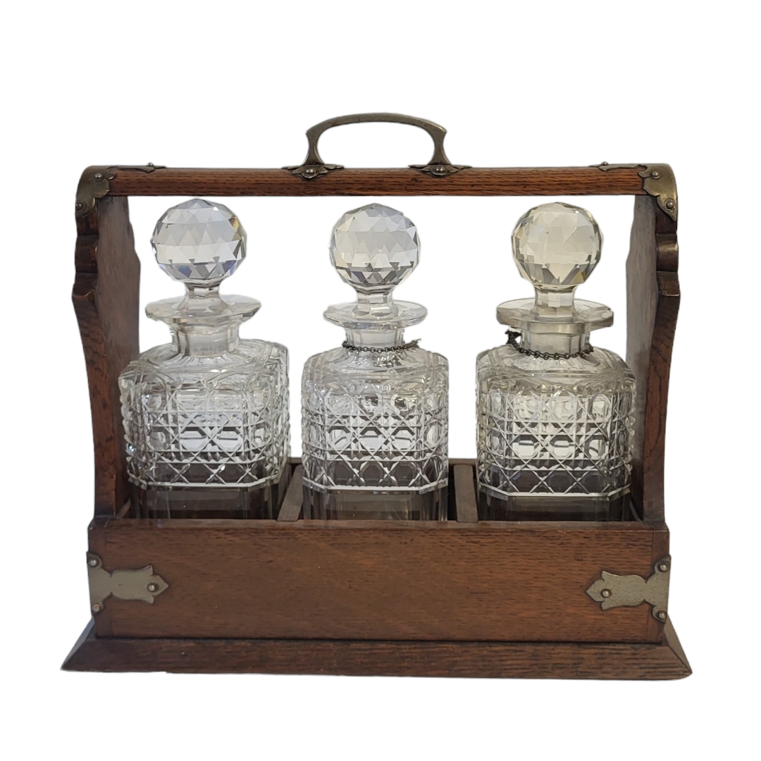 AN EARLY 20TH CENTURY OAK AND CUT GLASS TANTALUS Having silver plated corners, Bramah lock and three - Image 2 of 3