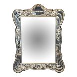 A 20TH CENTURY SILVER EASEL MIRROR Having embossed scrolled frame, hallmarked Birmingham, 1988, in