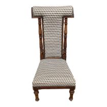 A LATE VICTORIAN BEECHWOOD PRAYER CHAIR In later fabric upholstery, on turned legs terminating on