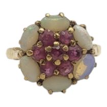 AN EARLY 20TH CENTURY 9CT GOLD RUBY AND OPAL RING The cluster of rubies edged with opals. (size J)
