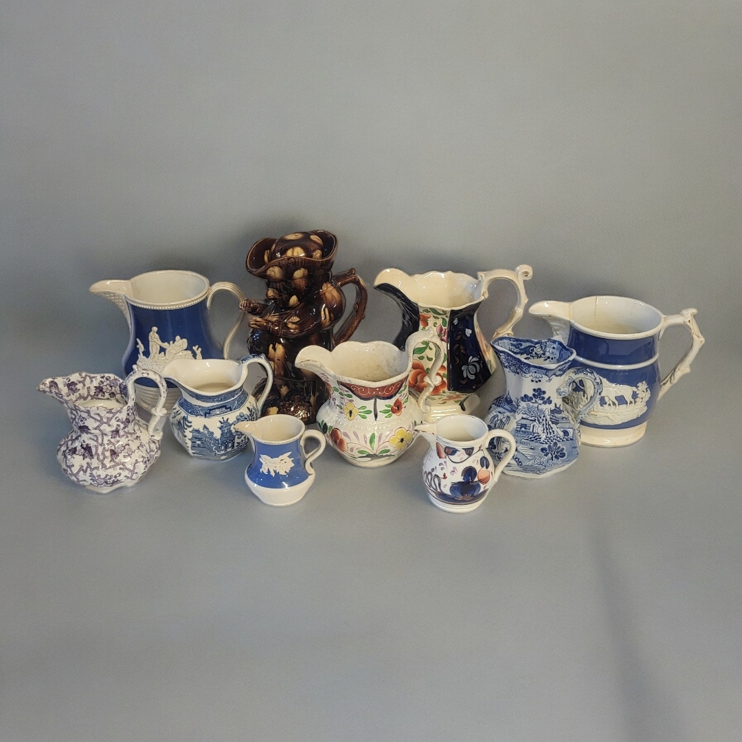 A COLLECTION OF EARLY 19TH CENTURY STAFFORDSHIRE POTTERY JUGS Comprising a treacle glazed Toby jug
