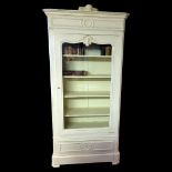 A 19TH FRENCH CREAM PAINTED BOOKCASE/DISPLAY CABINET Crested with a cartouche above a single