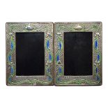 A PAIR OF ART NOUVEAU STYLE SILVER AND ENAMEL PHOTOGRAPH FRAMES Embossed floral design and wooden